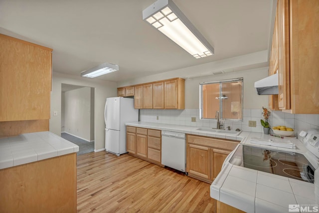 1308 Fremont, Carson City, NV 89701 - kitchen featuring white appliances, light wood finished floors, a sink, backsplash, and under cabinet range hood