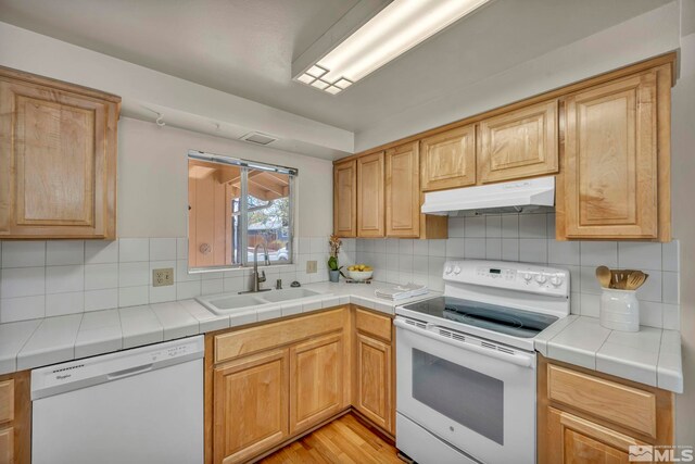 1308 Fremont, Carson City, NV 89701 - kitchen featuring white appliances, a sink, under cabinet range hood, tasteful backsplash, and light wood finished floors