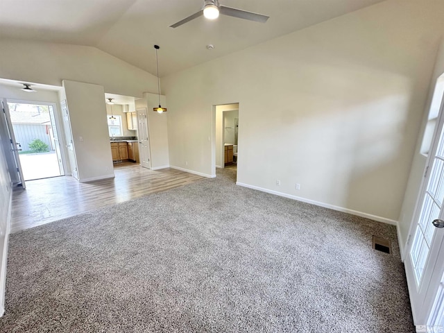 520 E Taylor St, Reno, NV 89502 - unfurnished living room with light colored carpet, a ceiling fan, vaulted ceiling, plenty of natural light, and baseboards