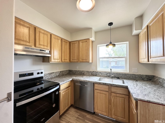 520 E Taylor St, Reno, NV 89502 - kitchen featuring appliances with stainless steel finishes, under cabinet range hood, a sink, light wood-style floors, and hanging light fixtures