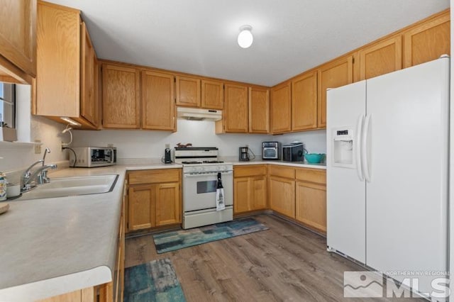 324 Occidental Dr, Dayton, NV 89403 - kitchen featuring white appliances, under cabinet range hood, a sink, light countertops, and wood finished floors