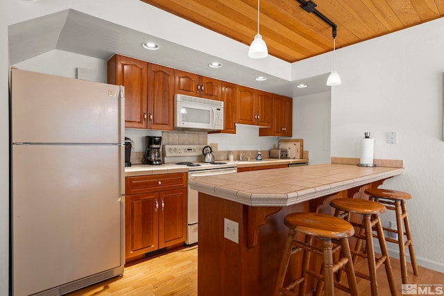 123 Juanita Dr Unit 2, Incline Village, NV 89451 - kitchen featuring white appliances, wood ceiling, light wood finished floors, recessed lighting, and a kitchen breakfast bar