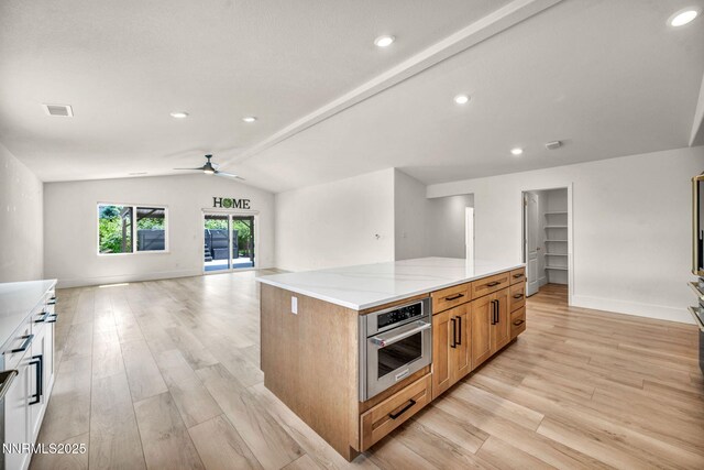 1144 Spruce Meadows Dr, Sparks, NV 89441 - kitchen featuring vaulted ceiling, open floor plan, stainless steel oven, ceiling fan, and light wood-style floors