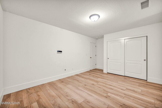1144 Spruce Meadows Dr, Sparks, NV 89441 - unfurnished bedroom featuring light wood finished floors, a closet, and a textured ceiling