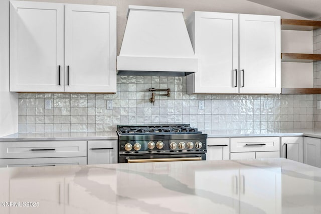 1144 Spruce Meadows Dr, Sparks, NV 89441 - kitchen with premium range hood, gas range oven, open shelves, white cabinetry, and backsplash
