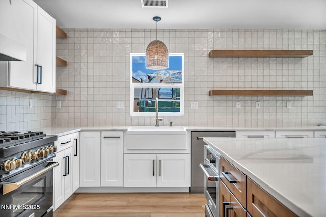 1144 Spruce Meadows Dr, Sparks, NV 89441 - kitchen with open shelves, high end stainless steel range oven, white cabinets, and decorative backsplash