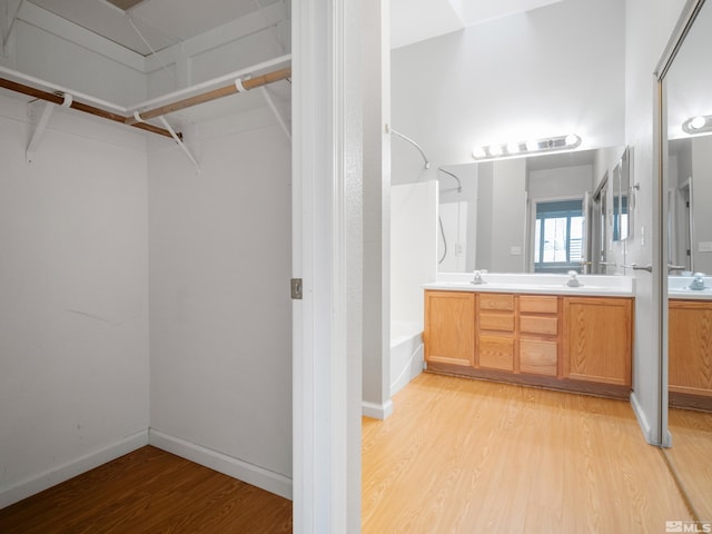 1308 Brooke Way, Gardnerville, NV 89410 - bathroom featuring wood finished floors, double vanity, shower / bathtub combination, a spacious closet, and baseboards