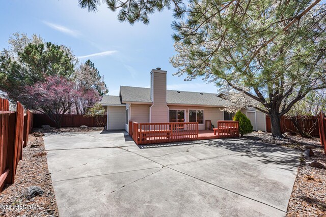 1774 Evergreen Ct, Minden, NV 89423 - rear view of property featuring a patio, a fenced backyard, a wooden deck, and a chimney