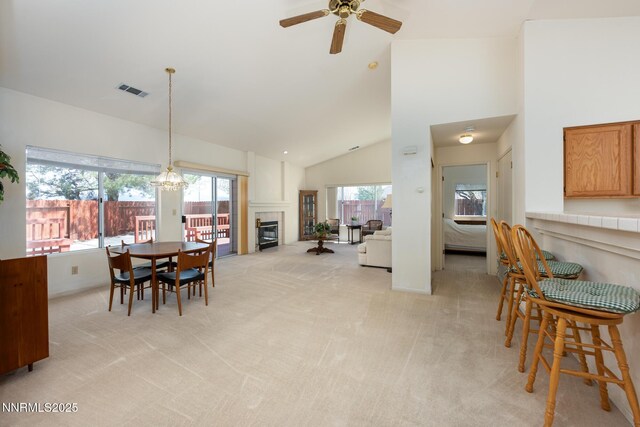 1774 Evergreen Ct, Minden, NV 89423 - dining space featuring light colored carpet, a ceiling fan, a fireplace, and high vaulted ceiling