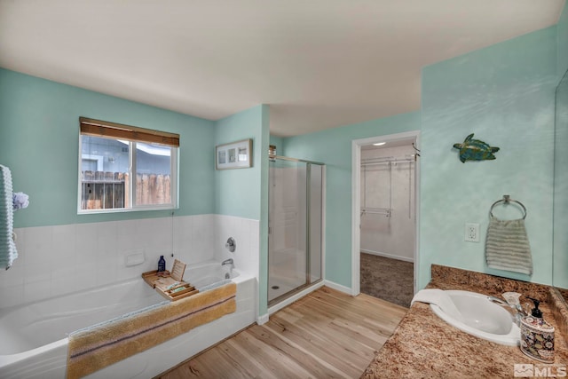 534 Dutch Oven Ct, Fernley, NV 89408 - full bath featuring wood finished floors, a shower stall, a bath, vanity, and baseboards