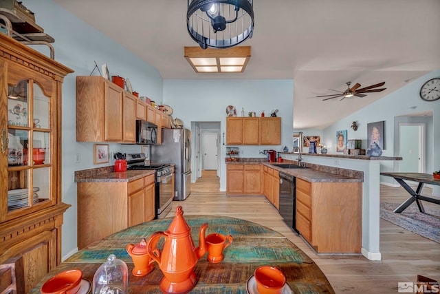534 Dutch Oven Ct, Fernley, NV 89408 - kitchen featuring black appliances, a peninsula, light wood finished floors, a sink, and vaulted ceiling