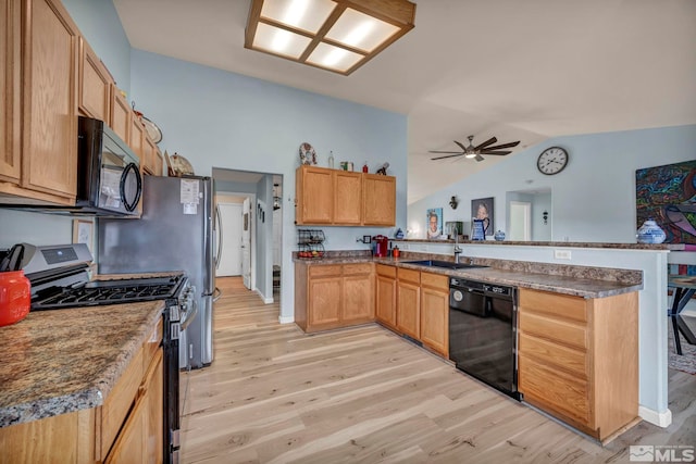 534 Dutch Oven Ct, Fernley, NV 89408 - kitchen featuring black appliances, a peninsula, lofted ceiling, a sink, and light wood-style floors