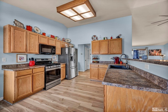 534 Dutch Oven Ct, Fernley, NV 89408 - kitchen with stainless steel appliances, a sink, light wood finished floors, dark countertops, and vaulted ceiling