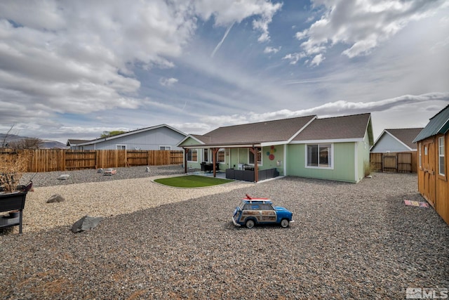 534 Dutch Oven Ct, Fernley, NV 89408 - rear view of property featuring a patio, a fenced backyard, an outdoor living space, and a shingled roof
