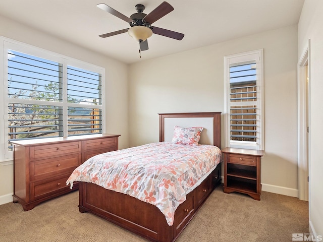 bedroom with light carpet, baseboards, and ceiling fan