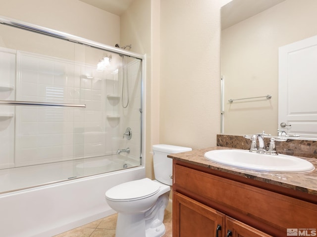 full bath featuring toilet, tile patterned flooring, shower / bath combination with glass door, and vanity