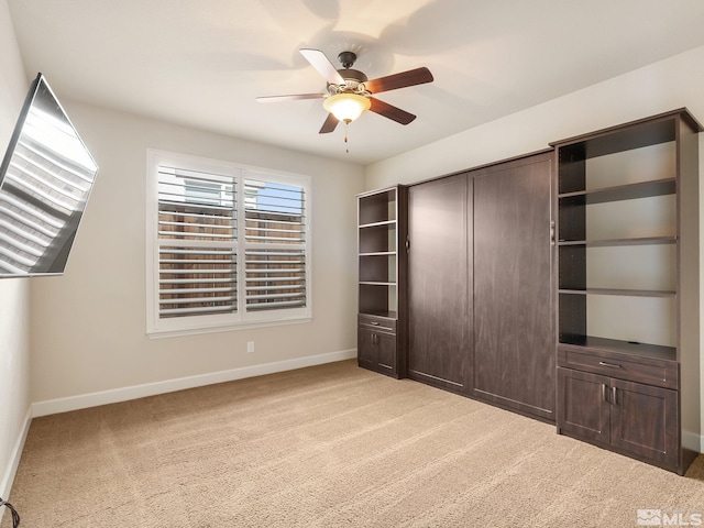 unfurnished bedroom featuring carpet flooring, baseboards, and a ceiling fan