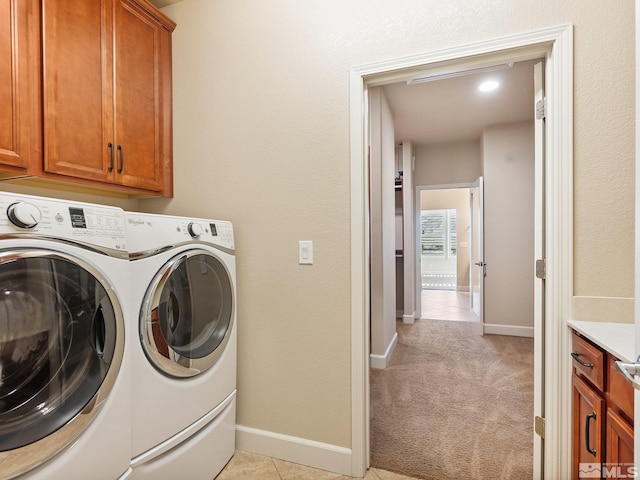 laundry room with separate washer and dryer, cabinet space, baseboards, and light carpet