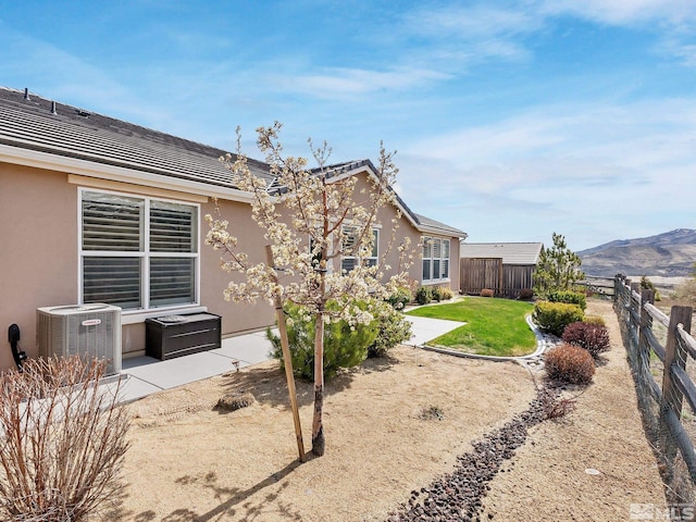 view of yard with central AC, a patio, and a mountain view