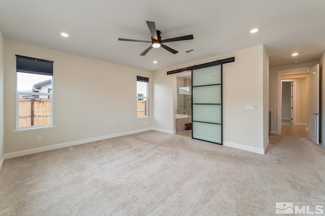 1023 Carico Valley Pl, Sparks, NV 89441 - unfurnished bedroom with a barn door, carpet flooring, baseboards, ensuite bath, and recessed lighting