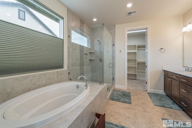 1023 Carico Valley Pl, Sparks, NV 89441 - bathroom featuring a stall shower, a spacious closet, vanity, a garden tub, and tile patterned flooring