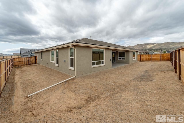 1023 Carico Valley Pl, Sparks, NV 89441 - rear view of property with a fenced backyard, stucco siding, a patio, and a mountain view
