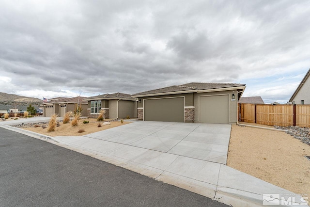 1023 Carico Valley Pl, Sparks, NV 89441 - view of front facade featuring fence, stucco siding, concrete driveway, and an attached garage