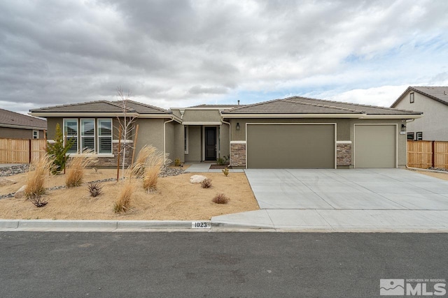 1023 Carico Valley Pl, Sparks, NV 89441 - view of front facade with stucco siding, a garage, driveway, fence, and a tiled roof