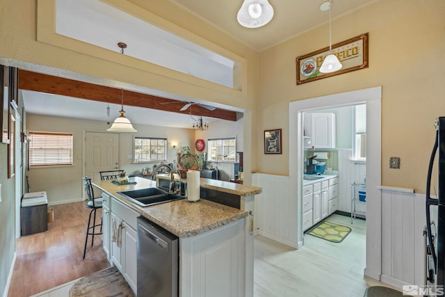 2640 Emily St, Reno, NV 89503 - kitchen with dishwasher, a sink, light wood-type flooring, white cabinets, and wainscoting