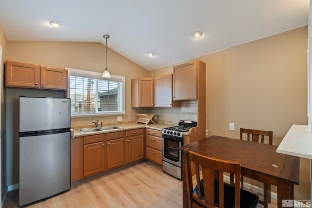2640 Emily St, Reno, NV 89503 - kitchen with appliances with stainless steel finishes, a sink, light wood-type flooring, vaulted ceiling, and decorative light fixtures