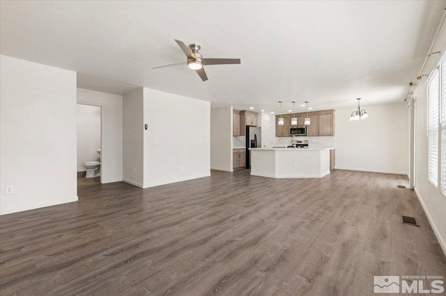 7753 Tulear St, Reno, NV 89506 - unfurnished living room featuring ceiling fan, wood finished floors, a chandelier, baseboards, and recessed lighting