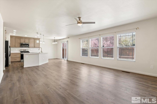 7753 Tulear St, Reno, NV 89506 - unfurnished living room featuring ceiling fan, a sink, dark wood finished floors, and a chandelier