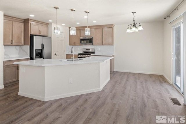 7753 Tulear St, Reno, NV 89506 - kitchen featuring appliances with stainless steel finishes, a sink, light wood finished floors, a chandelier, and recessed lighting