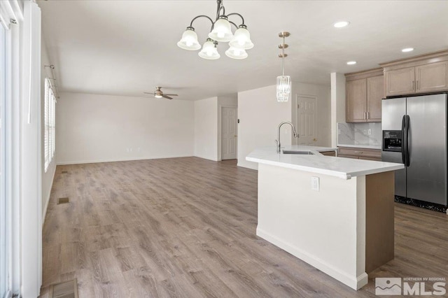 7753 Tulear St, Reno, NV 89506 - kitchen with stainless steel fridge, a sink, a ceiling fan, a chandelier, and light countertops