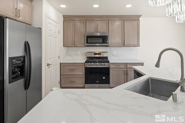7753 Tulear St, Reno, NV 89506 - kitchen with stainless steel appliances, a sink, light stone counters, recessed lighting, and backsplash
