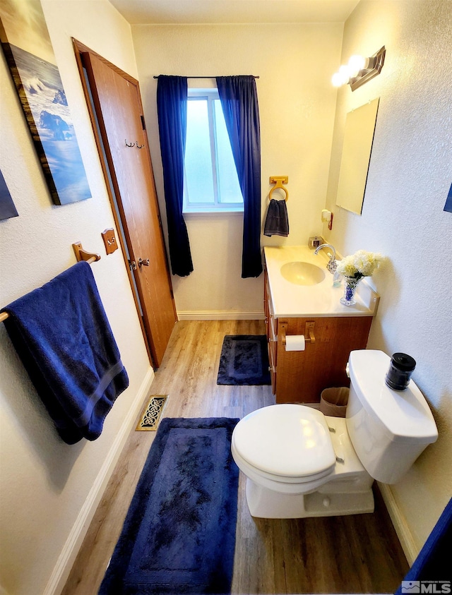 495 Burntwood St, Fallon, NV 89406 - bathroom featuring wood finished floors, toilet, vanity, and baseboards