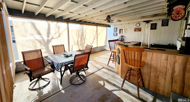 495 Burntwood St, Fallon, NV 89406 - dining space with ceiling fan, concrete floors, a bar, and wood walls