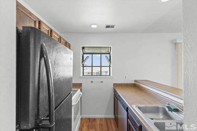 2165 Kietzke Ln Unit D, Reno, NV 89502 - kitchen featuring freestanding refrigerator, a sink, stainless steel dishwasher, electric range, and brown cabinets