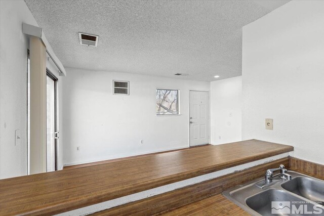 2165 Kietzke Ln Unit D, Reno, NV 89502 - kitchen with a sink, a textured ceiling, and wood finished floors