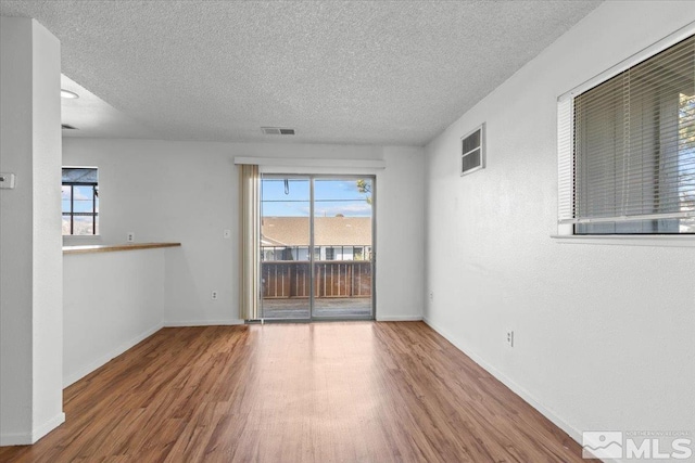 2165 Kietzke Ln Unit D, Reno, NV 89502 - empty room featuring a textured ceiling, wood finished floors, healthy amount of natural light, and baseboards