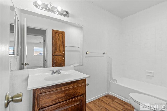 2165 Kietzke Ln Unit D, Reno, NV 89502 - full bathroom with wood finished floors, toilet, vanity, baseboards, and washtub / shower combination