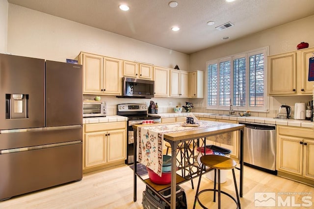 2078 Tivoli, Sparks, NV 89434 - kitchen with appliances with stainless steel finishes, tile countertops, recessed lighting, and light wood finished floors
