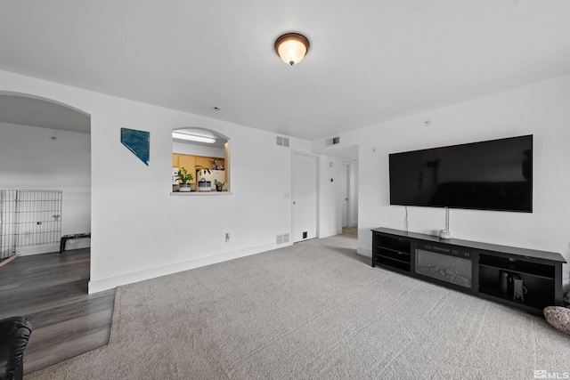 6850 Sharlands Ave # W2137, Reno, NV 89523 - unfurnished living room featuring baseboards, wood finished floors, and arched walkways