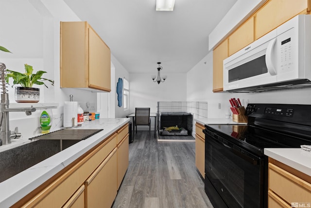 6850 Sharlands Ave # W2137, Reno, NV 89523 - kitchen featuring white microwave, black electric range oven, wood finished floors, light brown cabinetry, and decorative light fixtures
