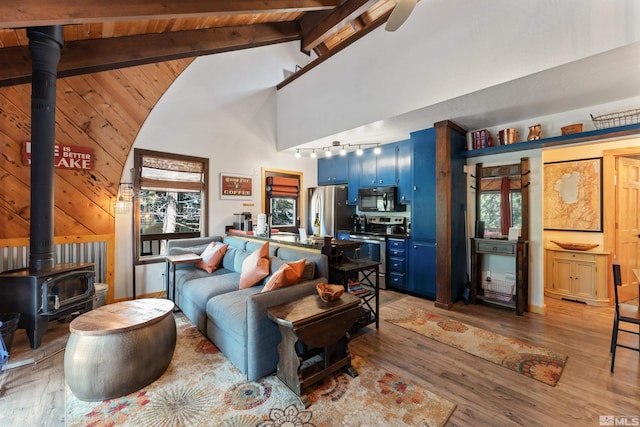 742 Tina Ct Unit B, Stateline, NV 89449 - living area featuring a wood stove, rail lighting, light wood-type flooring, beamed ceiling, and high vaulted ceiling