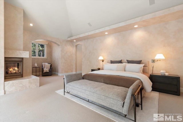 5680 Lausanne Dr, Reno, NV 89511 - bedroom with arched walkways, carpet flooring, a warm lit fireplace, recessed lighting, and baseboards
