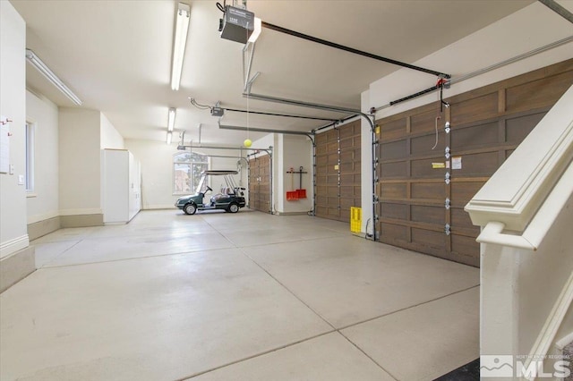 5680 Lausanne Dr, Reno, NV 89511 - garage featuring a garage door opener and baseboards