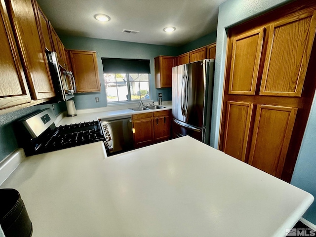 3131 Winter Rose Cir, Reno, NV 89502 - kitchen featuring appliances with stainless steel finishes, light countertops, a sink, a peninsula, and brown cabinets
