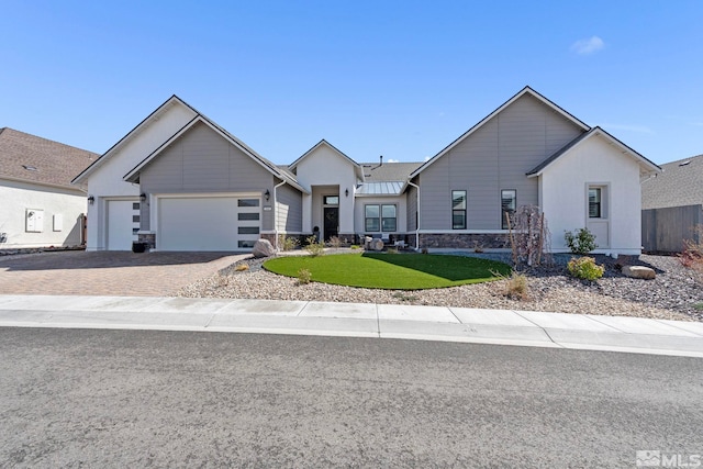 3060 Bristol Dr, Reno, NV 89521 - ranch-style house with an attached garage, driveway, a front yard, and stone siding