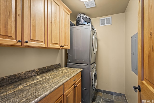 877 Northwood Blvd Unit 2, Incline Village, NV 89451 - clothes washing area featuring stacked washing machine and dryer, cabinet space, baseboards, stone tile floors, and electric panel